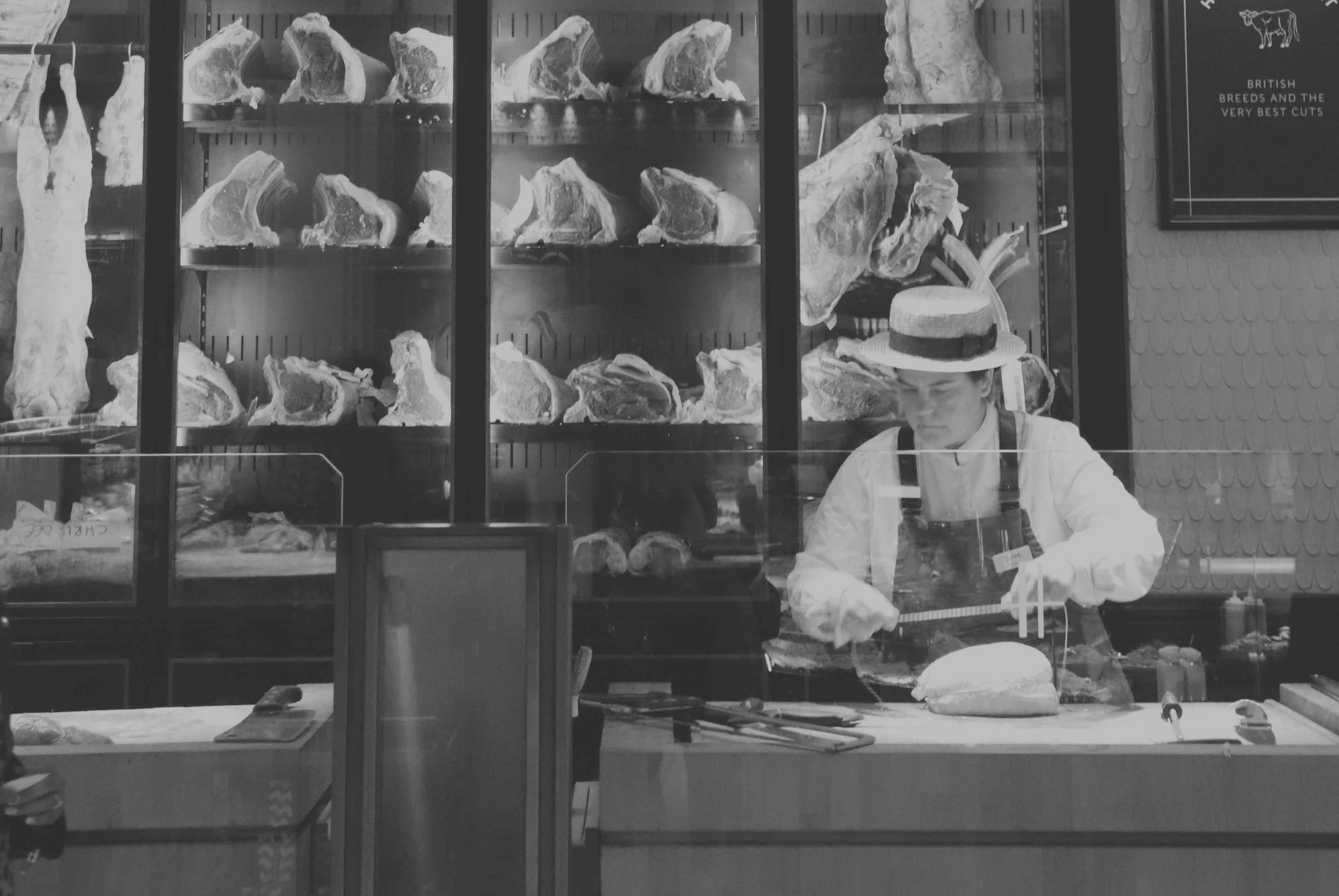 Black-and-white provisioner-like interior with a counter and equipment, shown as a documentary atmosphere.